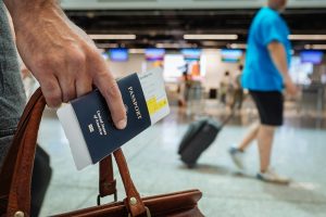 homem segura passaporte na mão no aeroporto