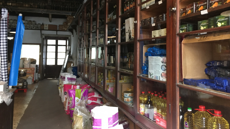 Conservas, farinhas, óleo, azeite e vinhos estão expostos nas prateleiras que preenchem as paredes