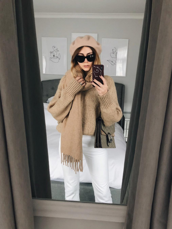 A blogger Emma Hill com uma blusa, um cachecol e uma boina beges 