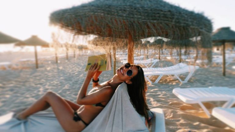 Na praia, a atriz ocupa o seu tempo com um livro 