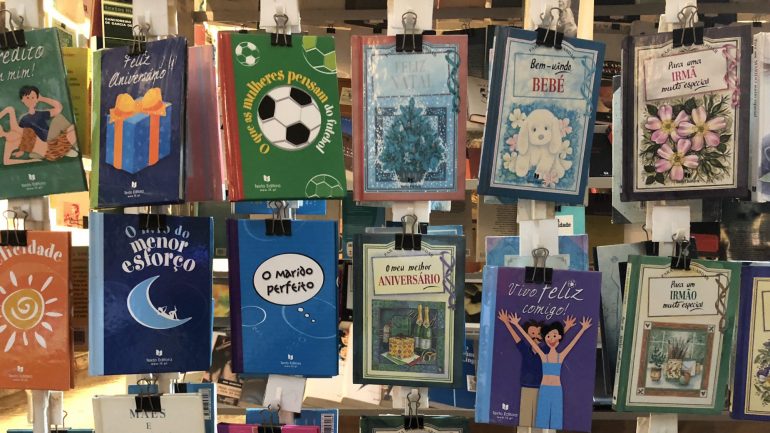 Todos os livros estão expostos pela capa, presos com uma mola, para que o cliente possa pegar e folhear