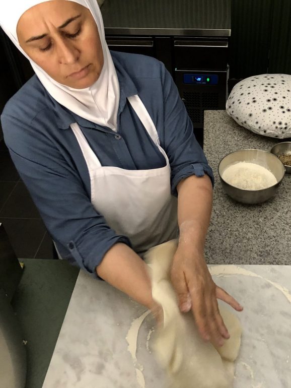 Mona faz a massa crescer com a ajuda de um rolo, uma almofada e o forno que dá nome ao espaço, o Saj